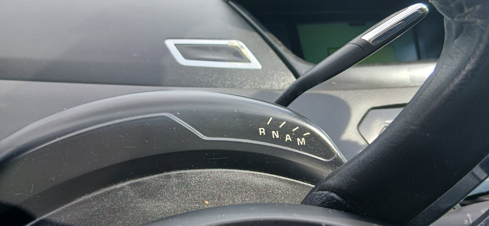 Zdjęcie przedstawia dźwignię i wskaźnik wyboru trybu jazdy w Citroën C4 Picasso, umieszczone nietypowo nad kolumną kierownicy.