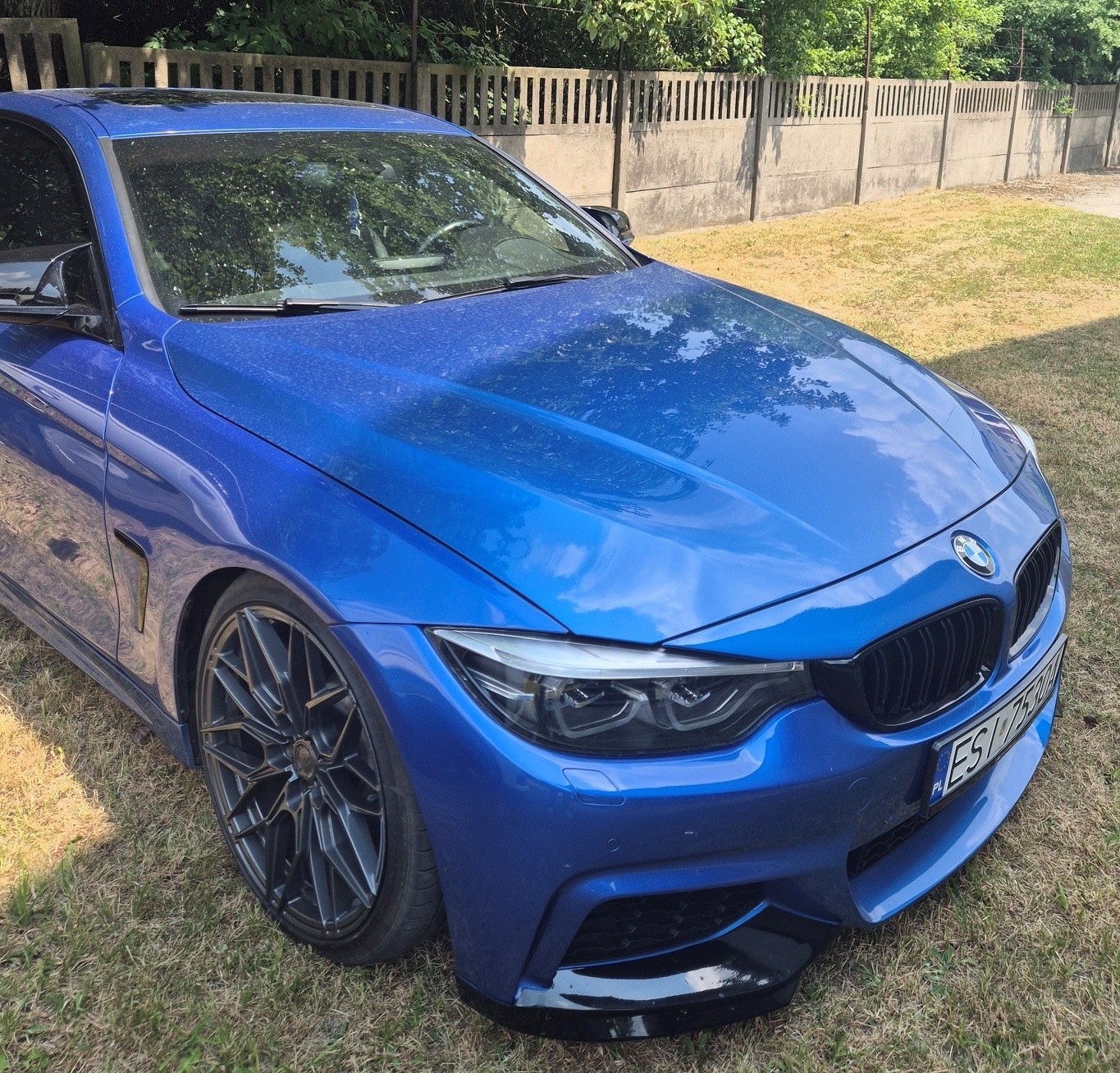 Niebieskie BMW z polską tablicą rejestracyjną, zdjęcie prawy przód.