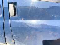 Niebieska karoseria vana Ford Transit z widoczną pionową czarną klamką drzwi