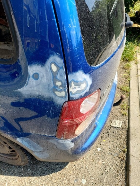 Uszkodzenia i braki w powłoce lakieru w okolicy lampy tylnej lewej
