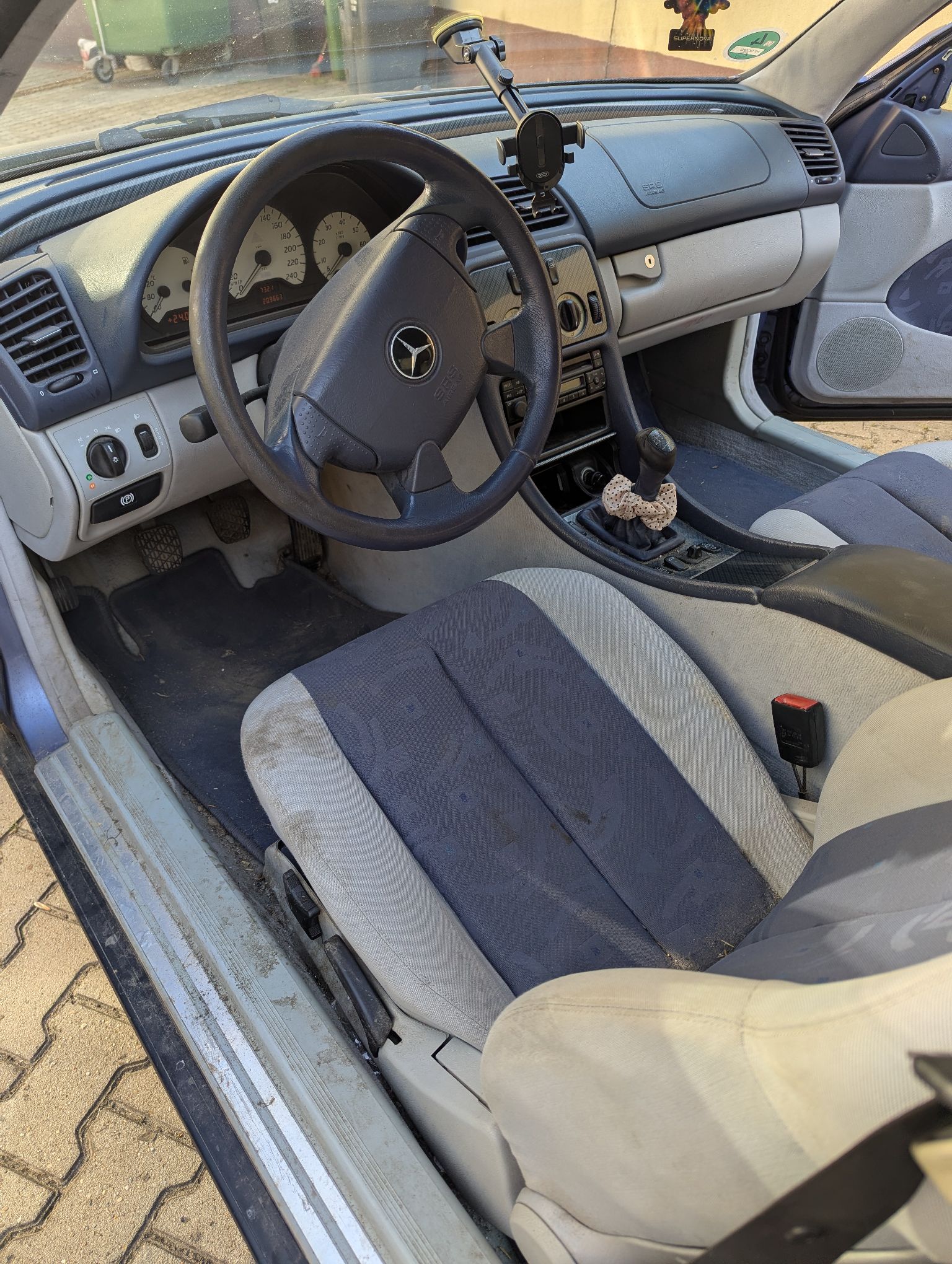 Wnętrze samochodu Mercedes-Benz CLK 200, beżowo granatowa tapicerka wymagająca odświeżenia, oryginalne radio.