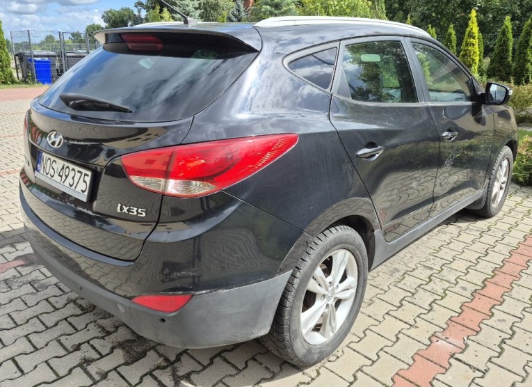 czarny Hyundai ix35, widok tył i prawy bok z widocznym dużym otarciem bez wgnieceń