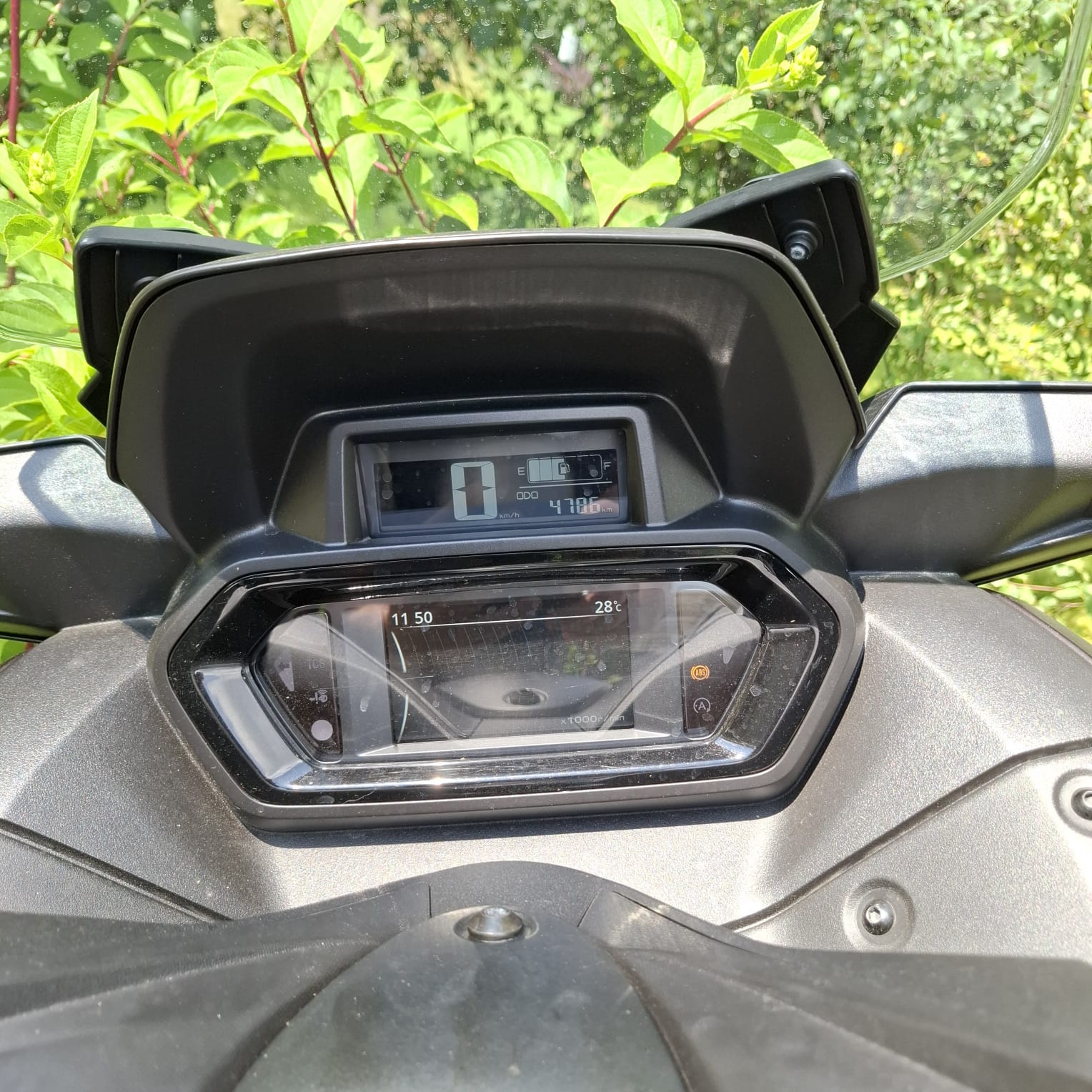 Cyfrowy wyświetlacz motocykla wskazuje prędkość 0 km/h, przebieg 4786 km oraz temperaturę 28°C.