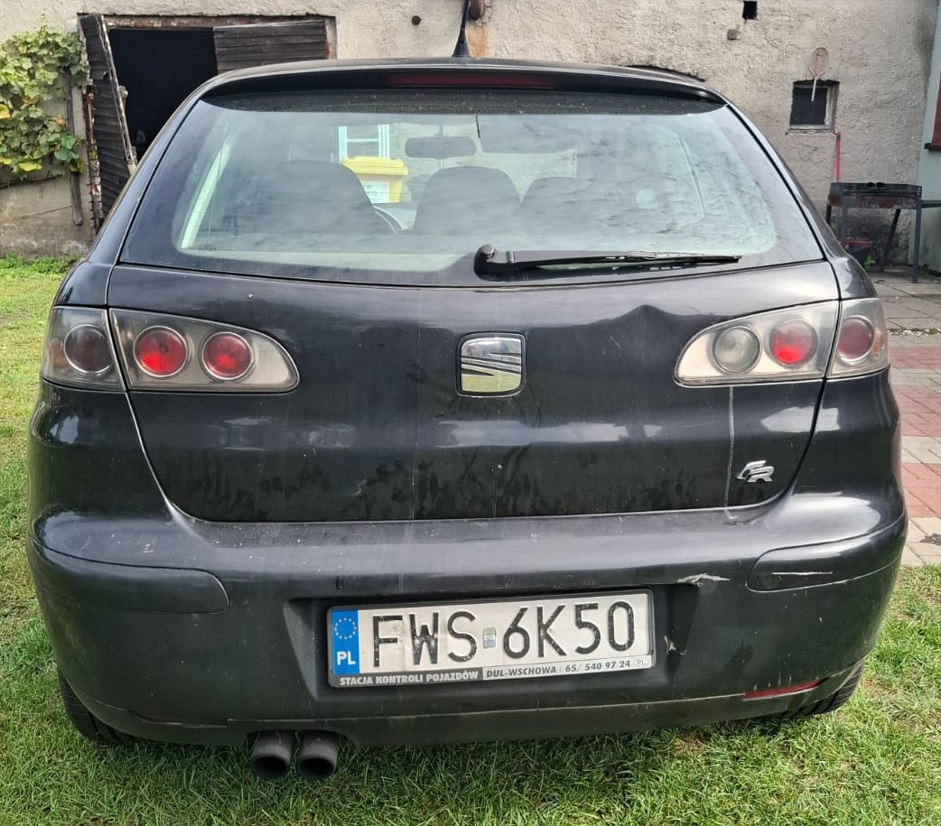 Tył czarnego Seata Ibizy z widocznym emblematem FR na klapie bagażnika oraz widocznymi uszkodzeniami lakieru