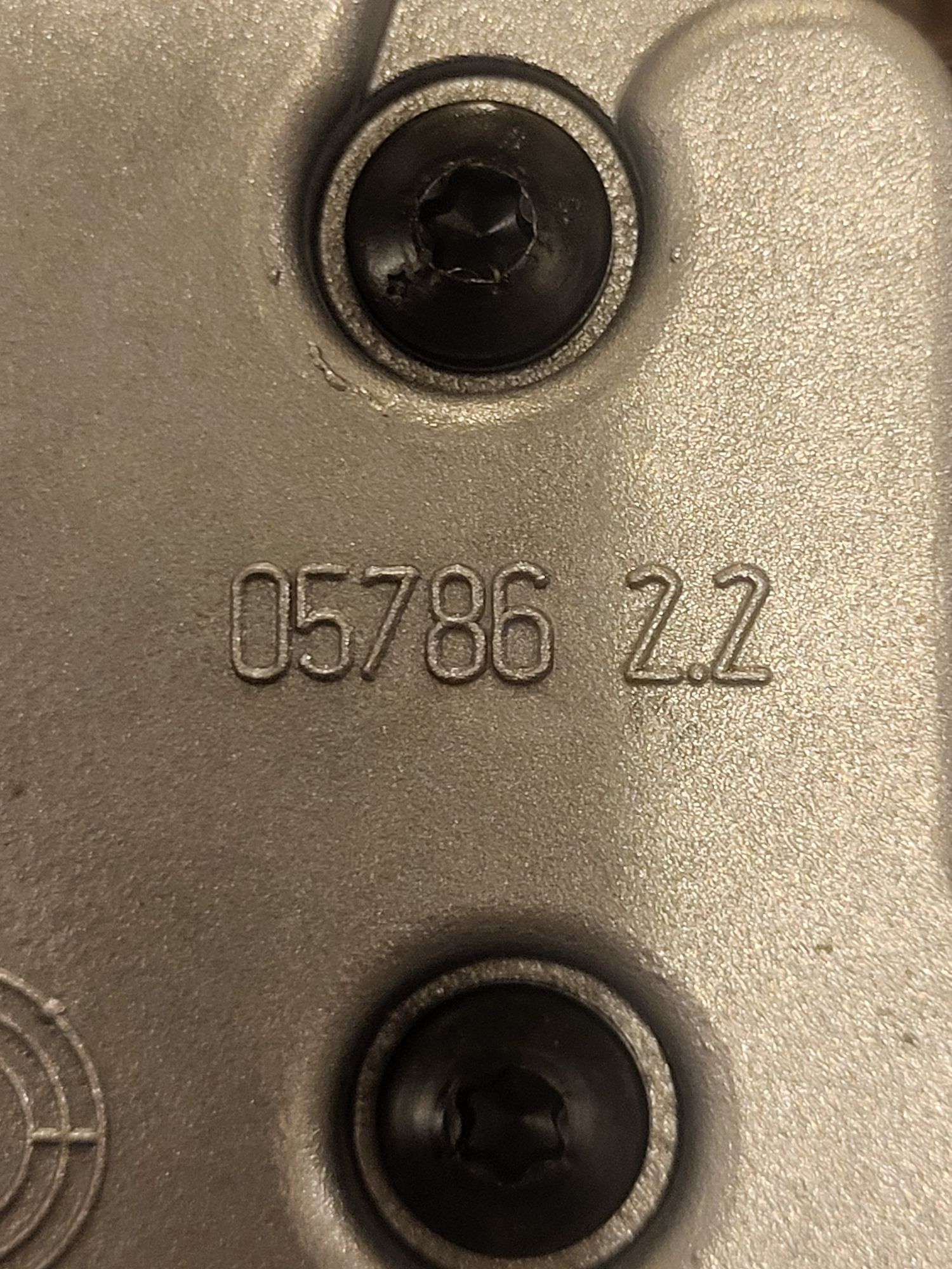 metalowy element skrzyni biegów z wybitą sekwencją cyfr i znaków „05786 2.2”