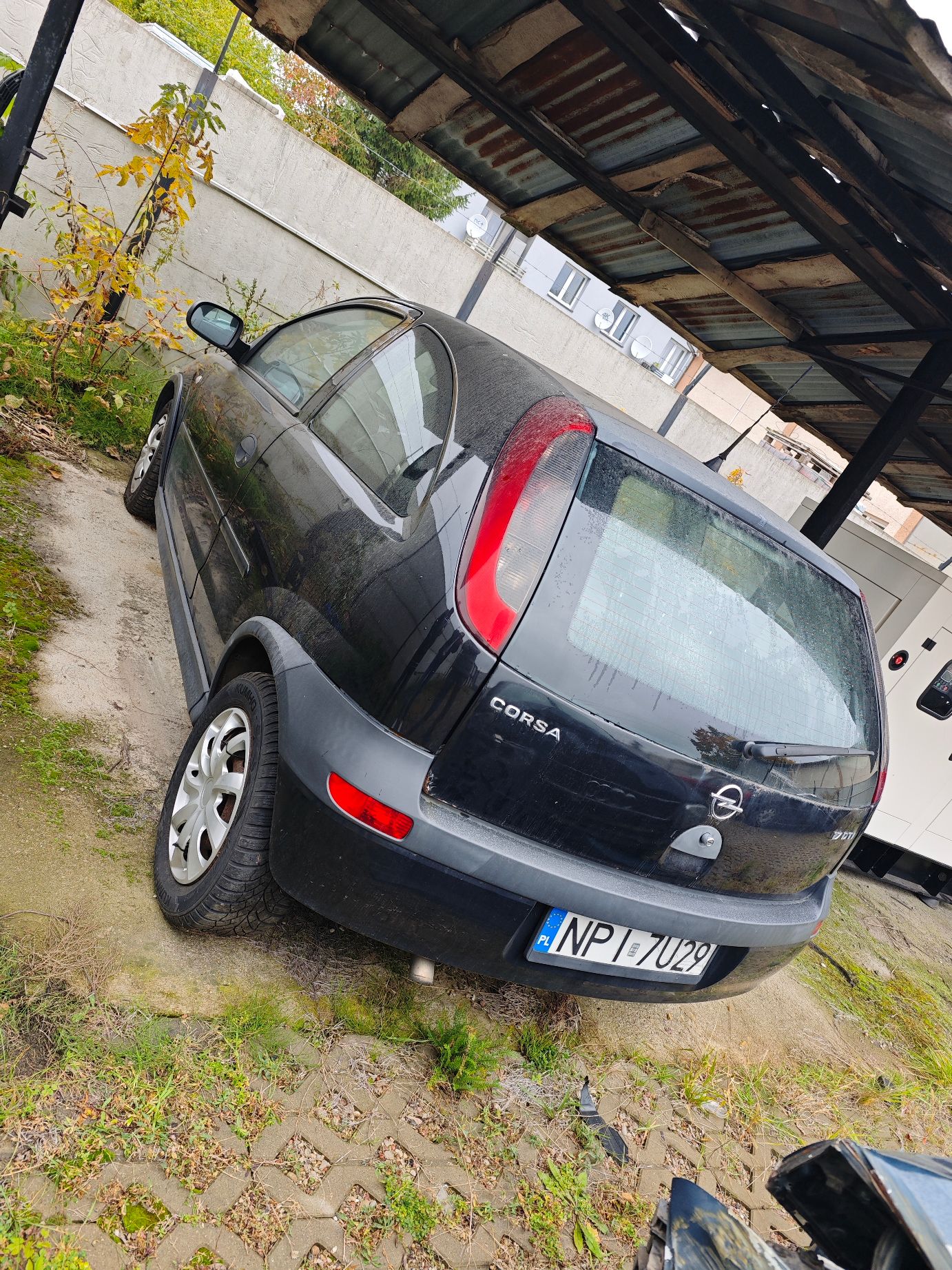 Tył czarnego samochodu Opel Corsa C z widoczną tablicą rejestracyjną NPI 7U29 lewa strona pojazdu