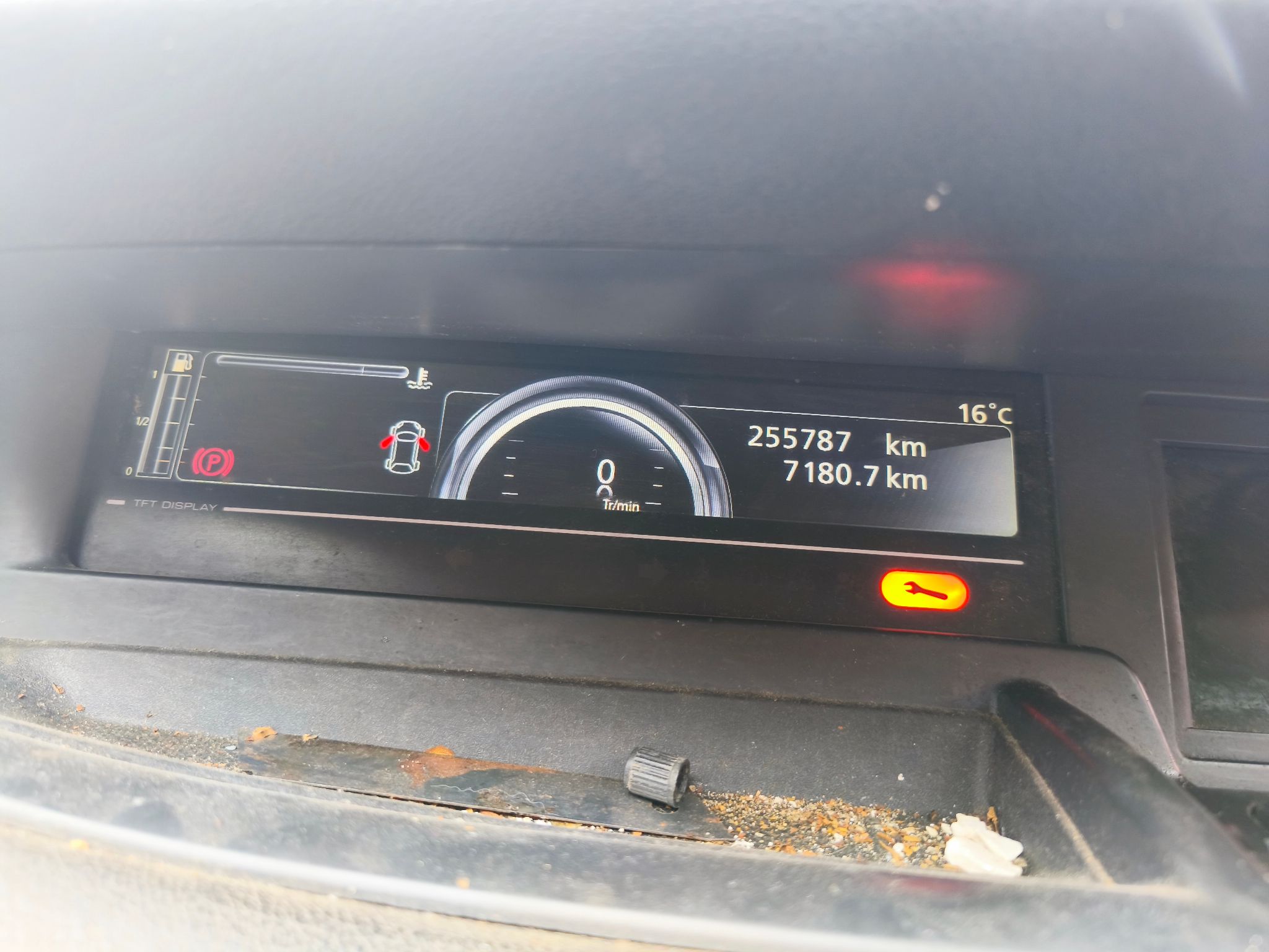 widok deski rozdzielczej. Zabrudzenia widoczny przebieg 255787 km. świeci się pomarańczowy klucz
