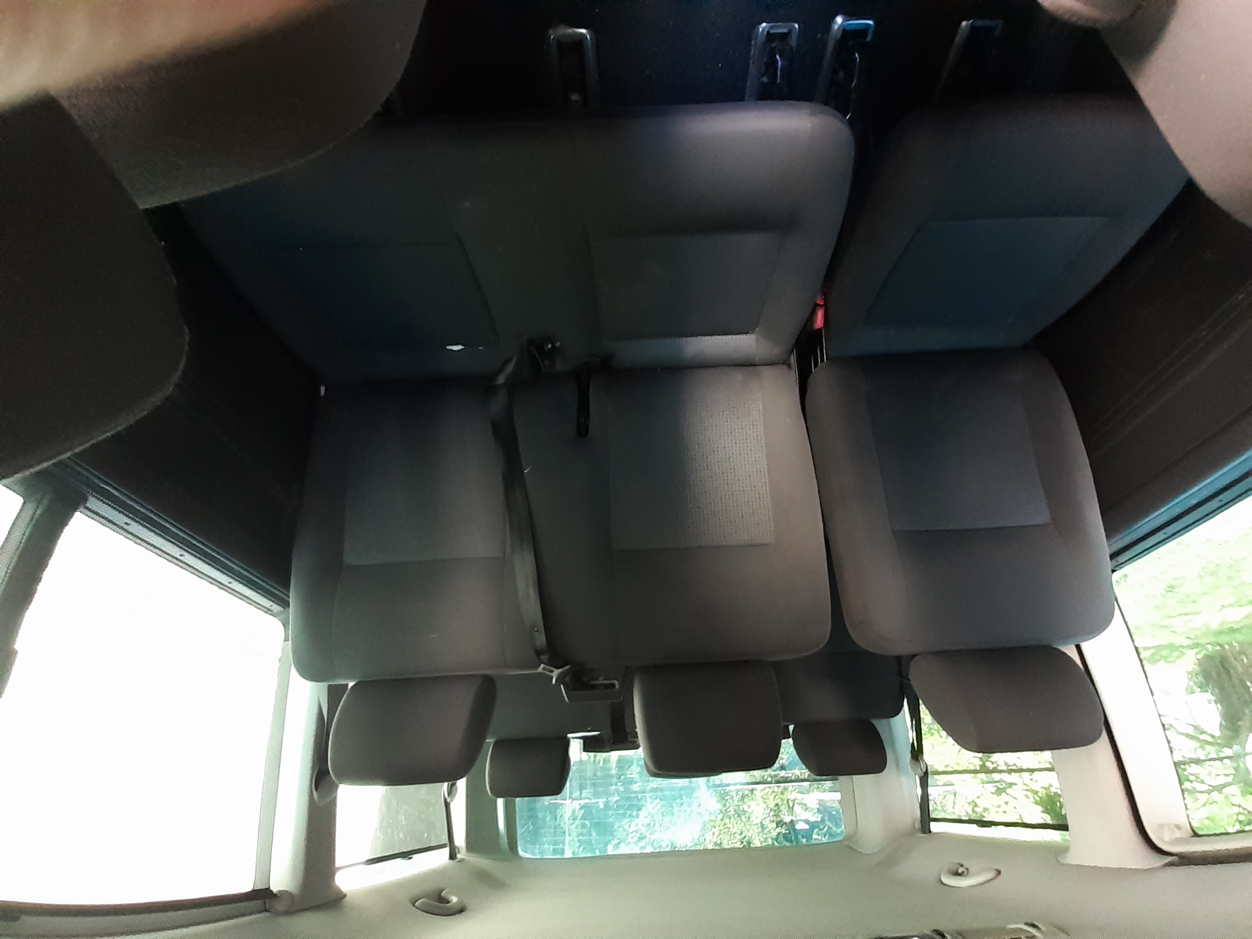 Widok wnętrza srebrnego Volkswagena Caravelle z perspektywy tylnej części pojazdu