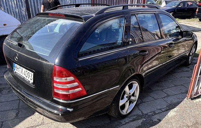 Samochód Mercedes-Benz C 180 w kolorze czarnym widoczny od tyłu z prawej strony.