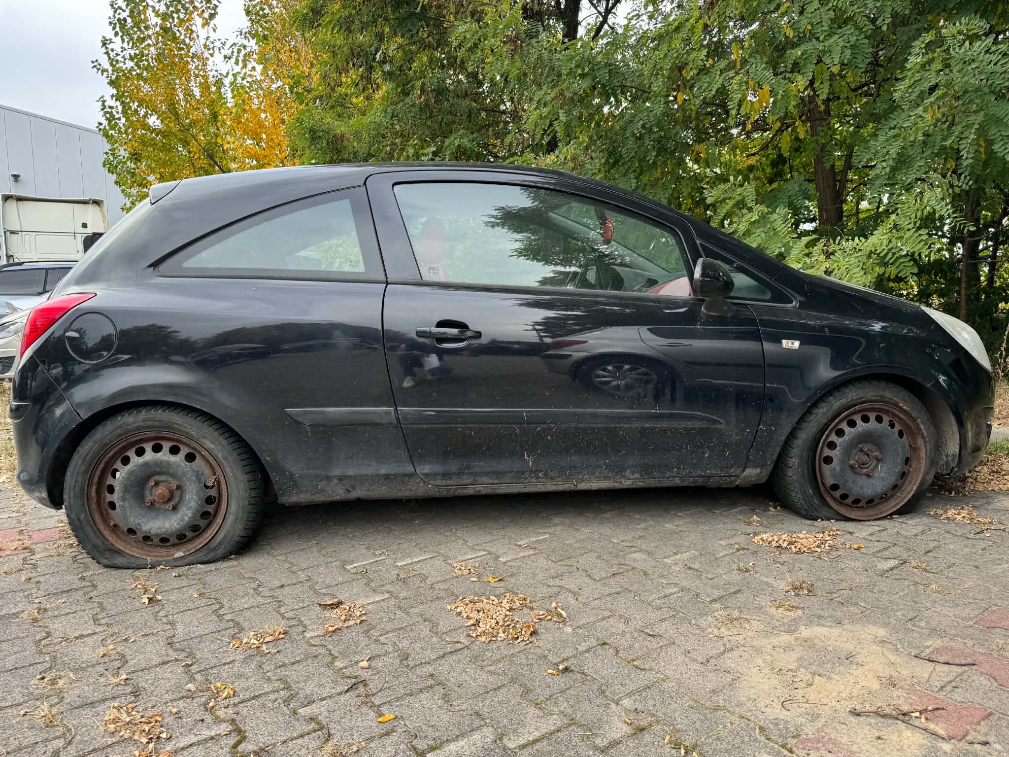 Zdjęcie przedstawia prawą stronę pojazdu. Karoseria w kolorze czarnym. Widoczny brak powietrza w oponach.