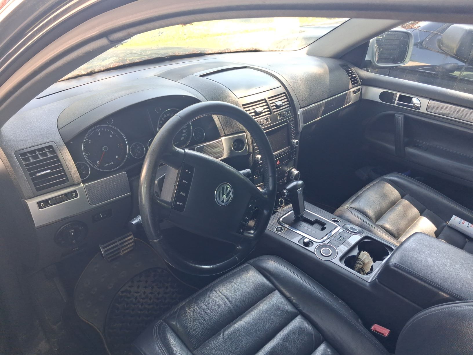 Wnętrze czarnego Volkswagena Touarega widziane od strony kierowcy.