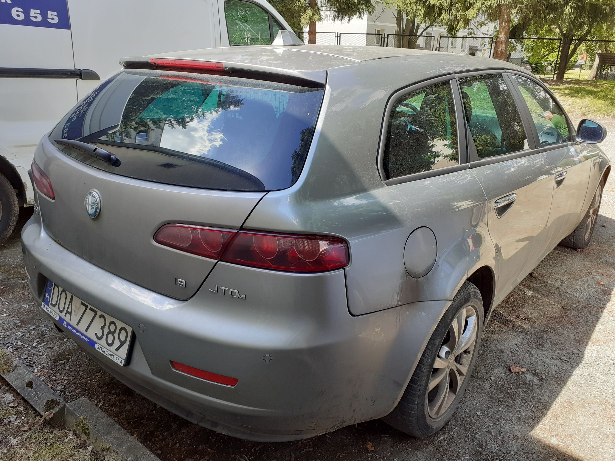Tył i prawy bok srebrnego pięciodrzwiowego samochodu osobowego marki Alfa Romeo 159 Sportwagon (wersja kombi)