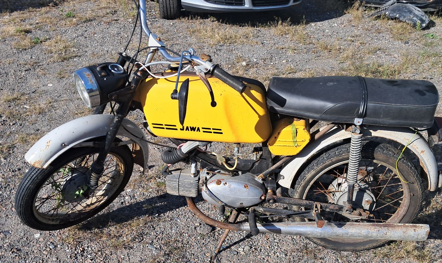 Widoczny jest motorower, układ kierowniczy, koła , siedzenie, zdjęcie zrobione z góry