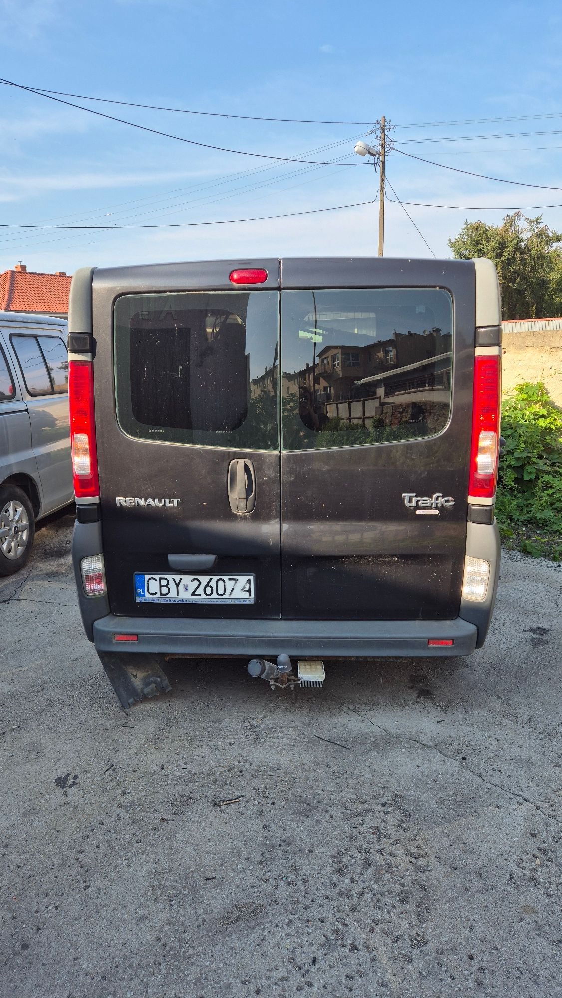 Tył nadwozia Renault Trafic koloru czarnego. Na zderzaku zamontowany hak holowniczy.