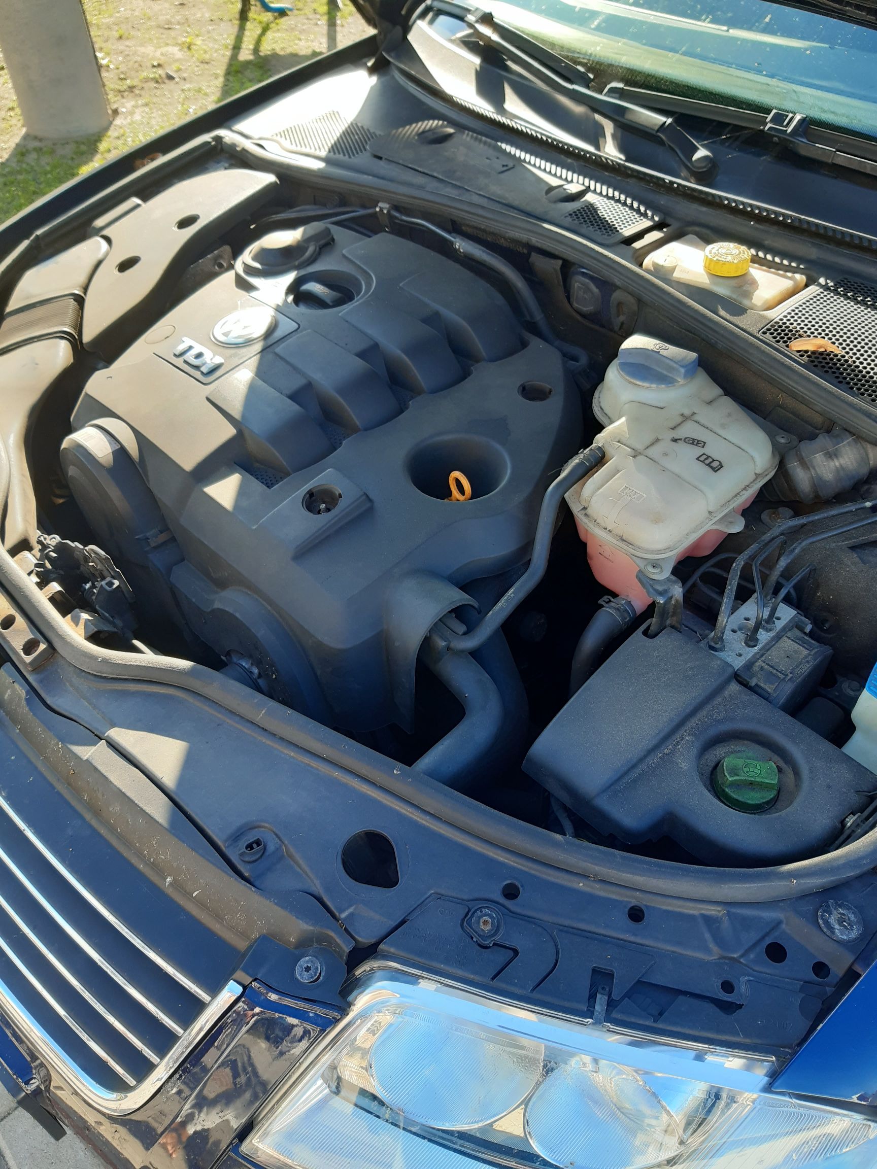 Widok pod maskę Volkswagena z silnikiem wysokoprężnym TDI, z widoczną plastikową osłoną i zbiorniczkami płynów.