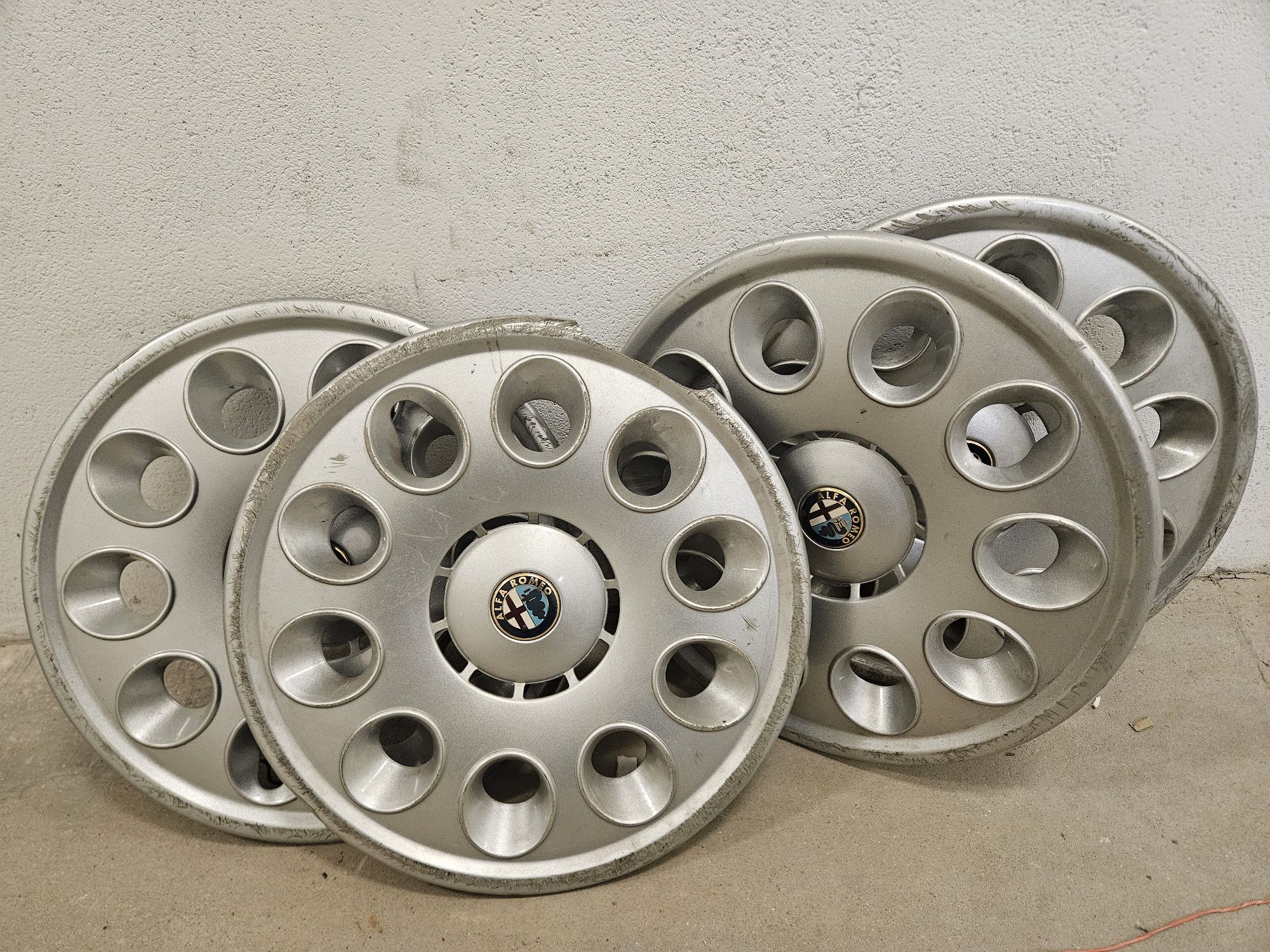 cztery srebrne kołpaki ze znaczkiem Alfa Romeo