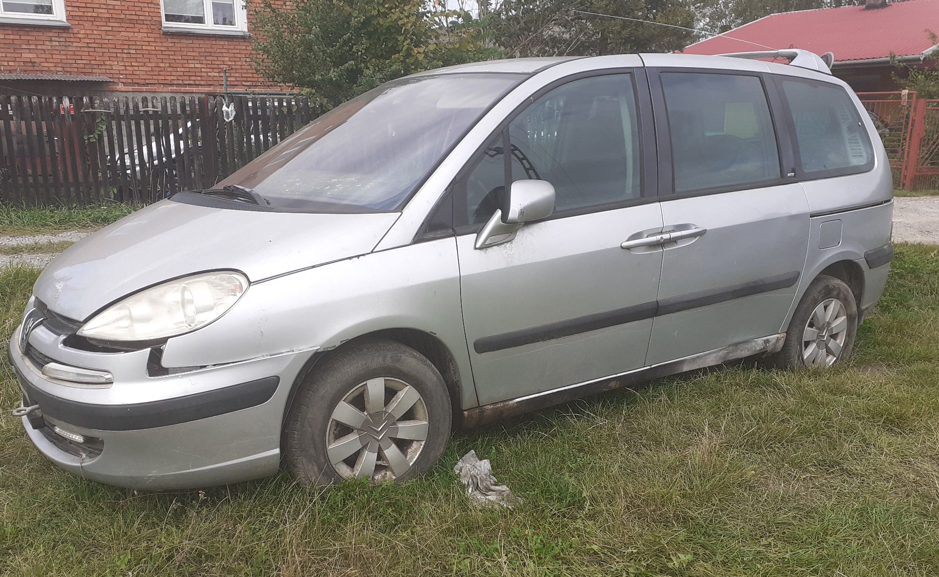 Srebrny samochód osobowy Peugeot typu minivan widoczny z boku ze śladami korozji na progu.