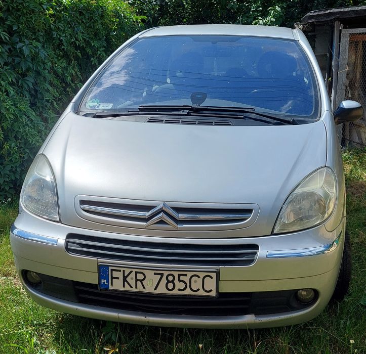 Przód srebrnego Citroena Xsara Picasso, widoczne otarcia zderzaka.