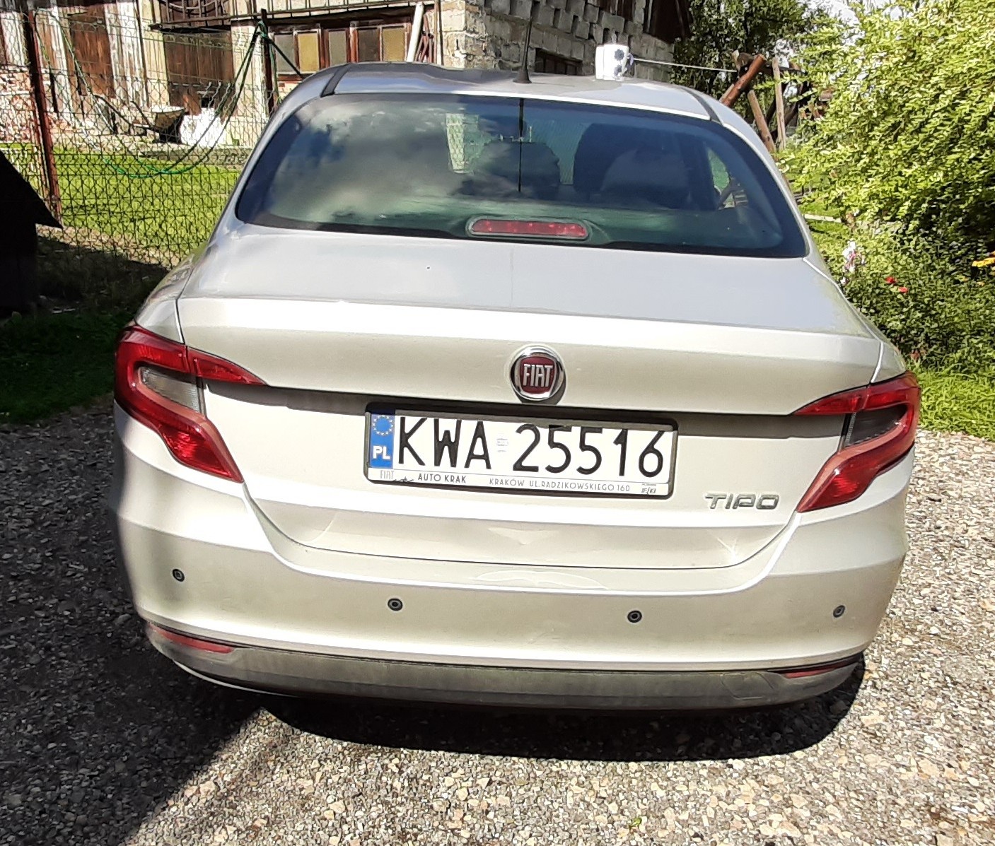 Srebrny FIAT TIPO widoczny z tylnymi światłami, logo Fiata oraz oznaczeniem modelu „Tipo”. Tylna szyba z wycieraczką.