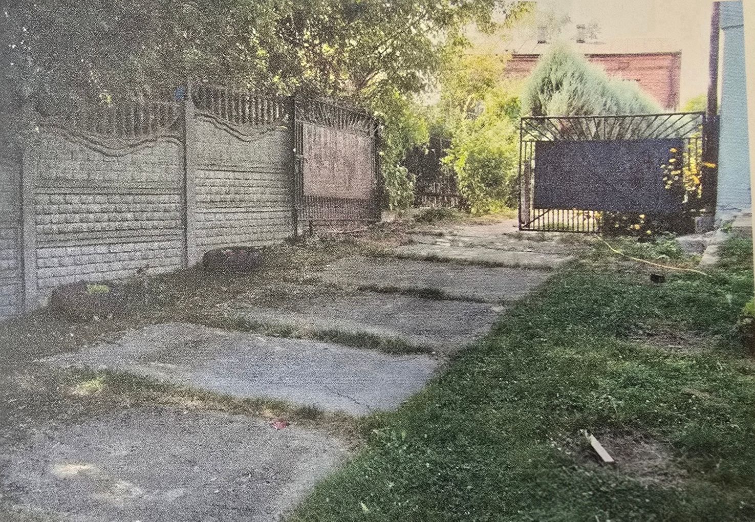 Podjaz z płyt betonowych i bramą wjazdową stalową dwuskrzydłową, ogrodzenie z płyt betonowych z dekoracyjnymi panelami.