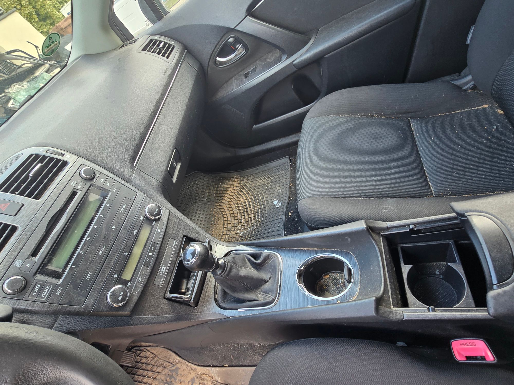 Wnętrze Toyoty Avensis z widocznymi uszkodzeniami oraz zabrudzeniami tapicerki