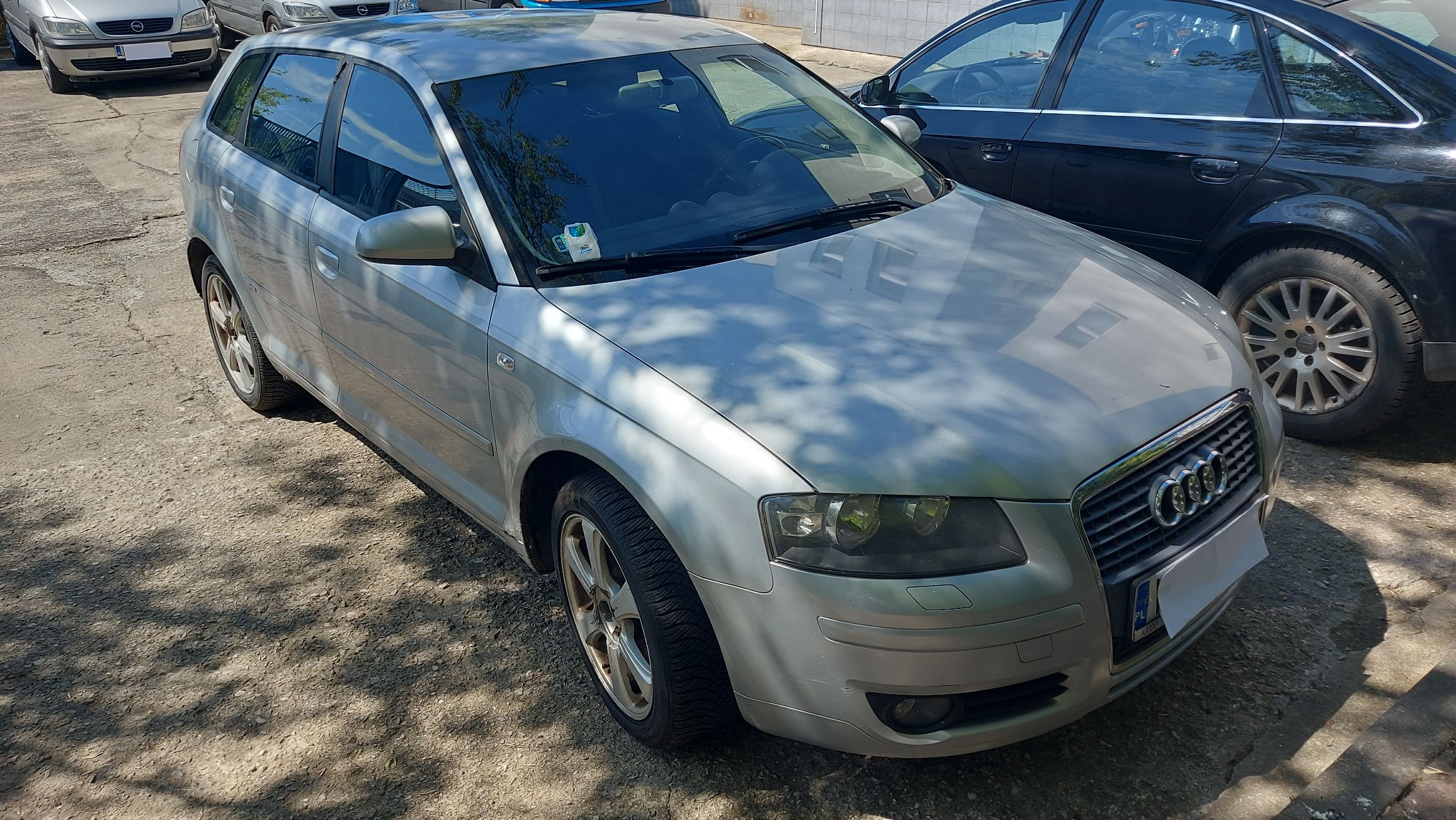 Przód i lewy profil srebrnego samochodu Audi A3 generacji 8P w wersji pięciodrzwiowej.