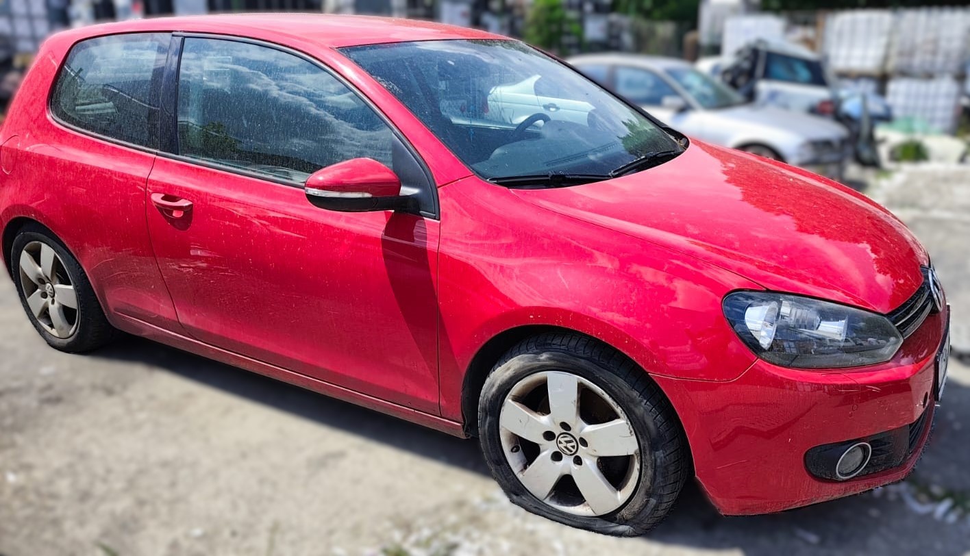 Prawy bok czerwonego Volkswagena Golfa z widocznym uszkodzeniem zderzaka