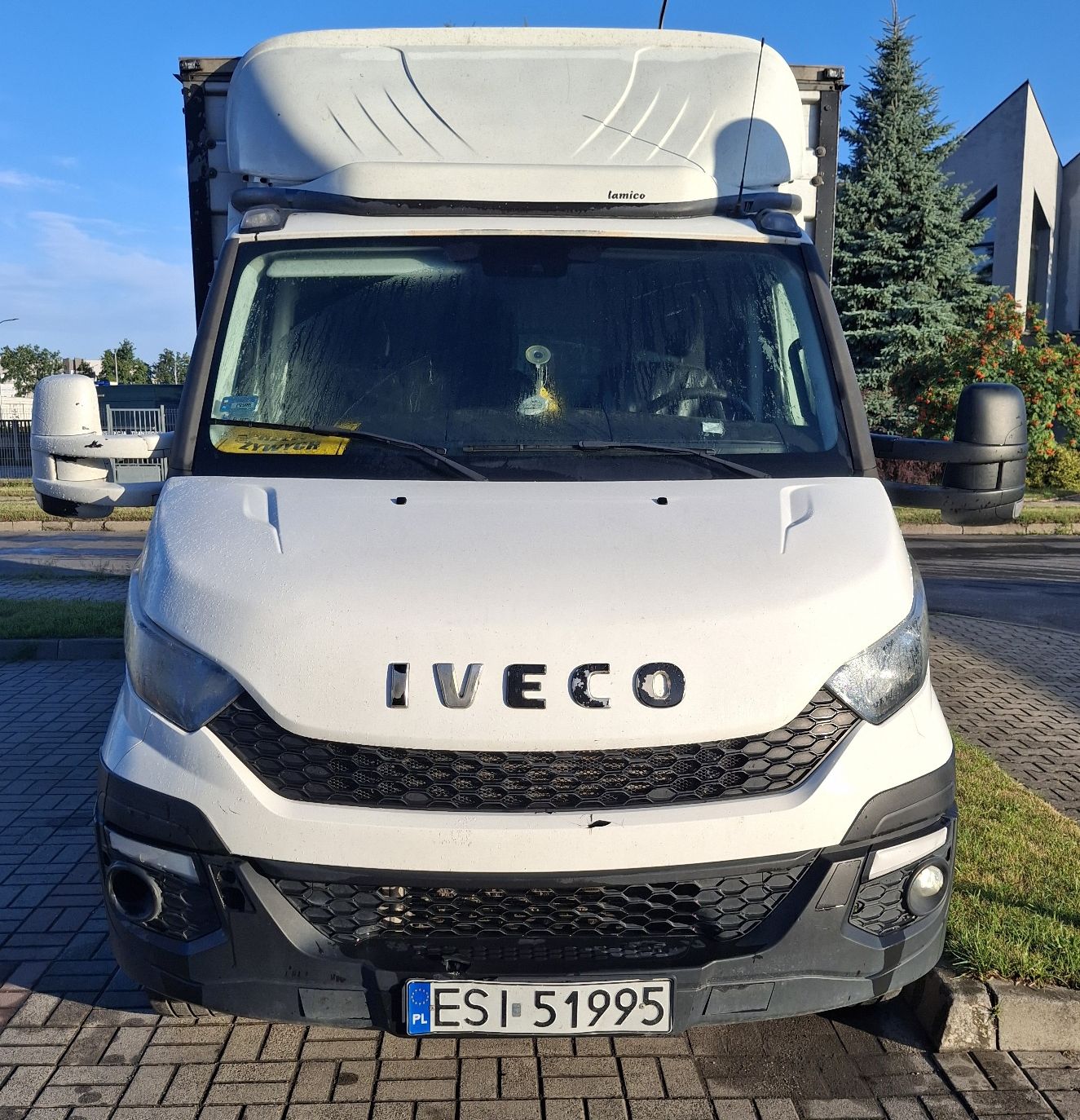 Białe Iveco Daily od przodu. Widoczny czarny grill i napis IVECO.