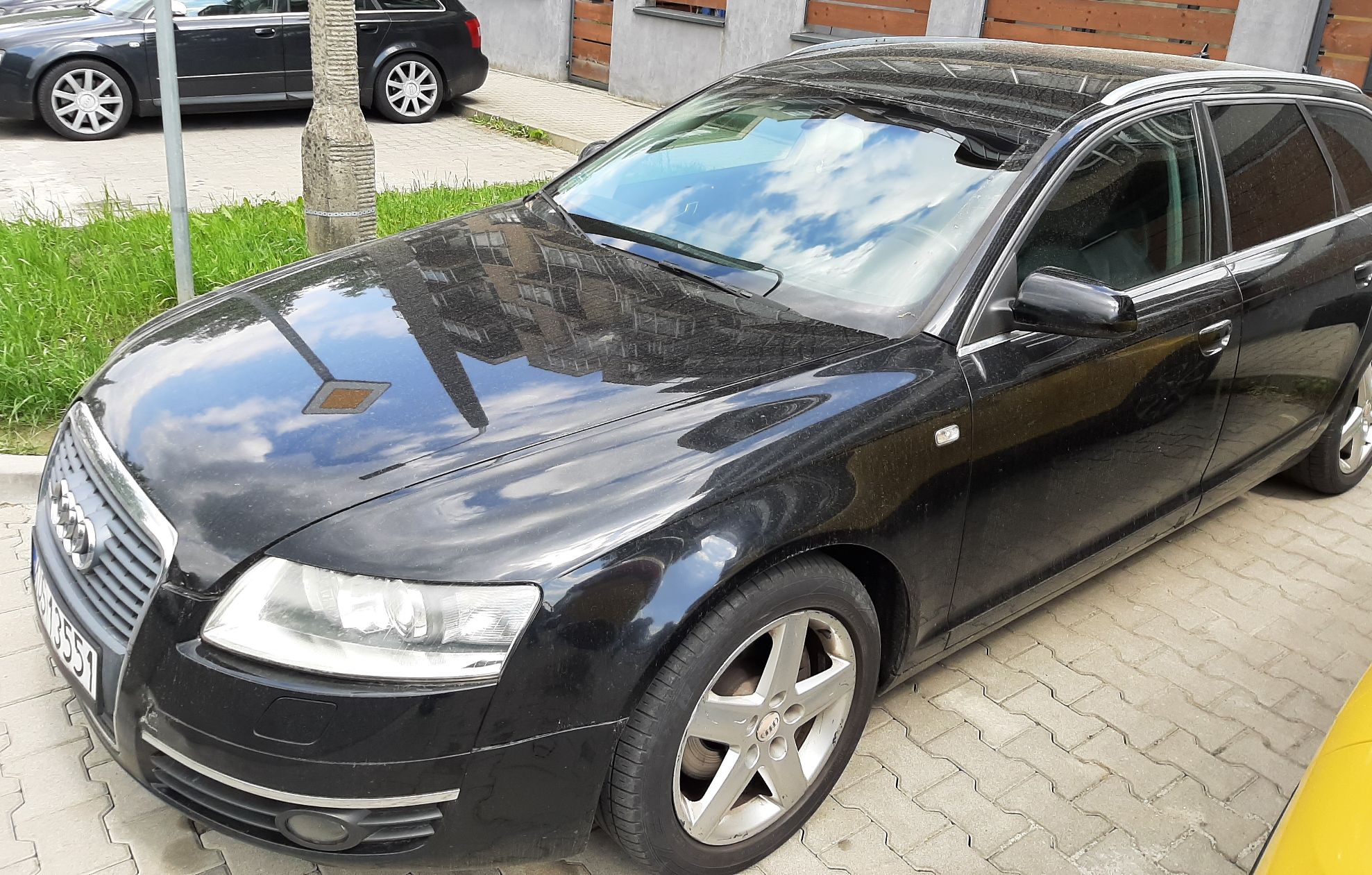 Czarny samochód Audi kombi z widocznym przodem i lewym bokiem pojazdu z alufelgami