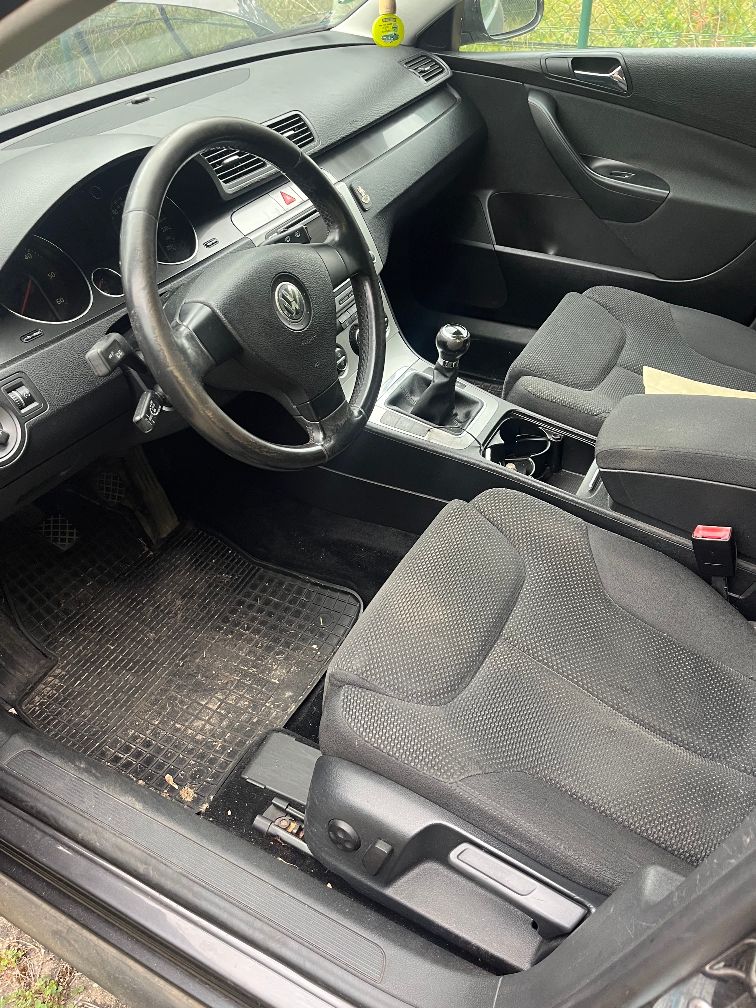 Wnętrze Volkswagena Passata od strony kierowcy z widoczną 6-biegową manualną skrzynią biegów i ciemną, materiałową tapicerką.
