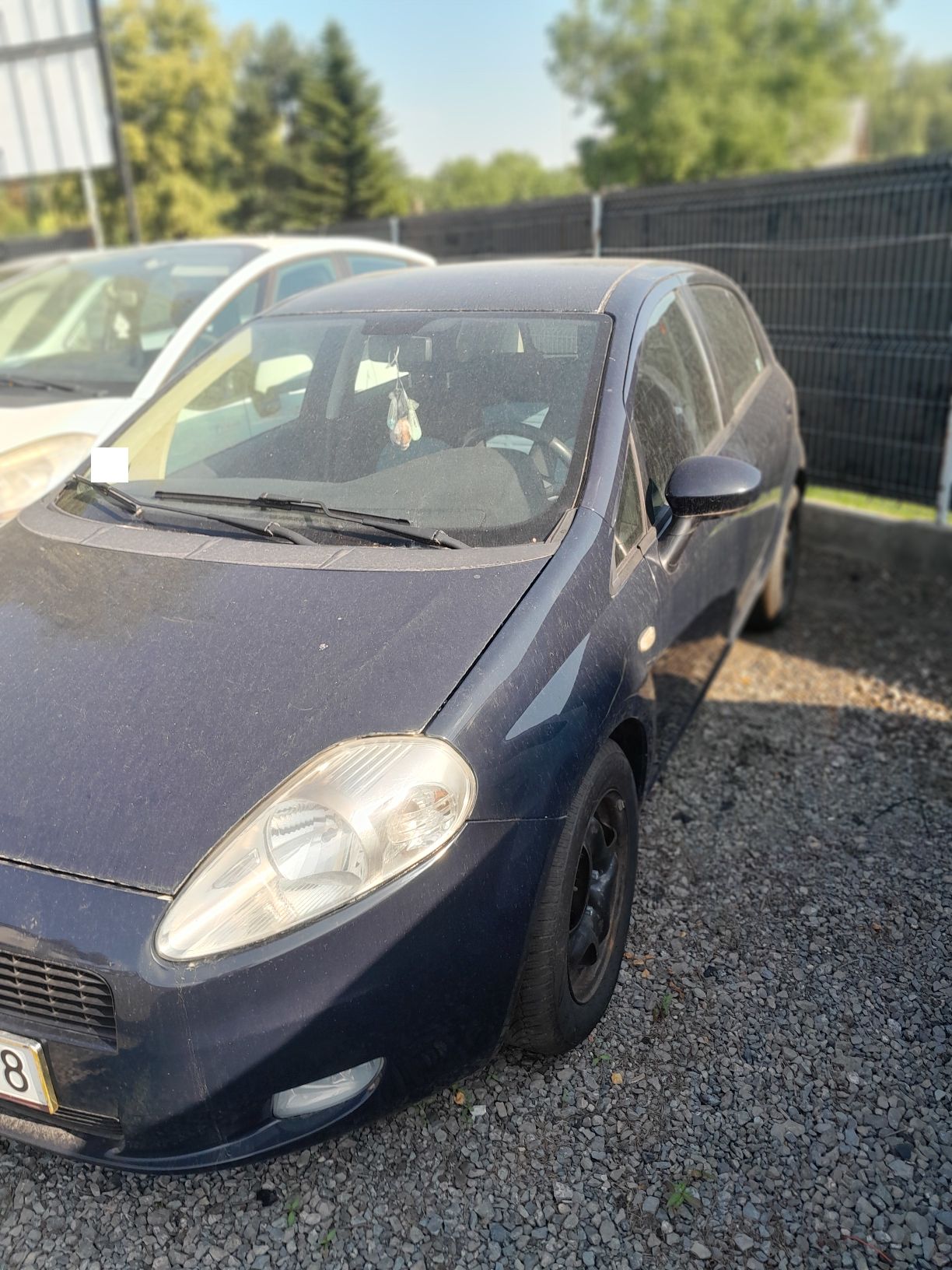 Granatowy Fiat Punto, ujęcie lewej strony pojazdu.