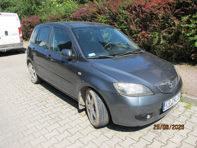 Przód i prawy bok pojazdu Mazda 2 koloru szarego.
