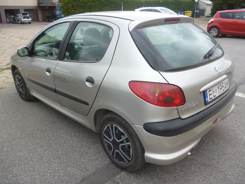 Zdjęcie przedmiotu. Tył lewy pojazdu osobowego Peugeot 206.