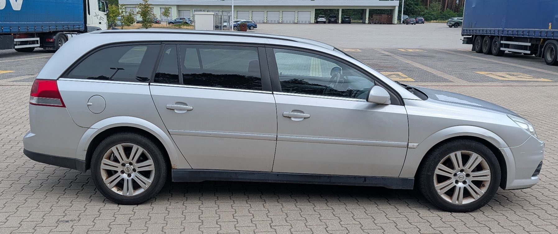 Prawy bok samochodu z listwą boczną na drzwiach, stalowe felgi, widoczne ślady użytkowania.