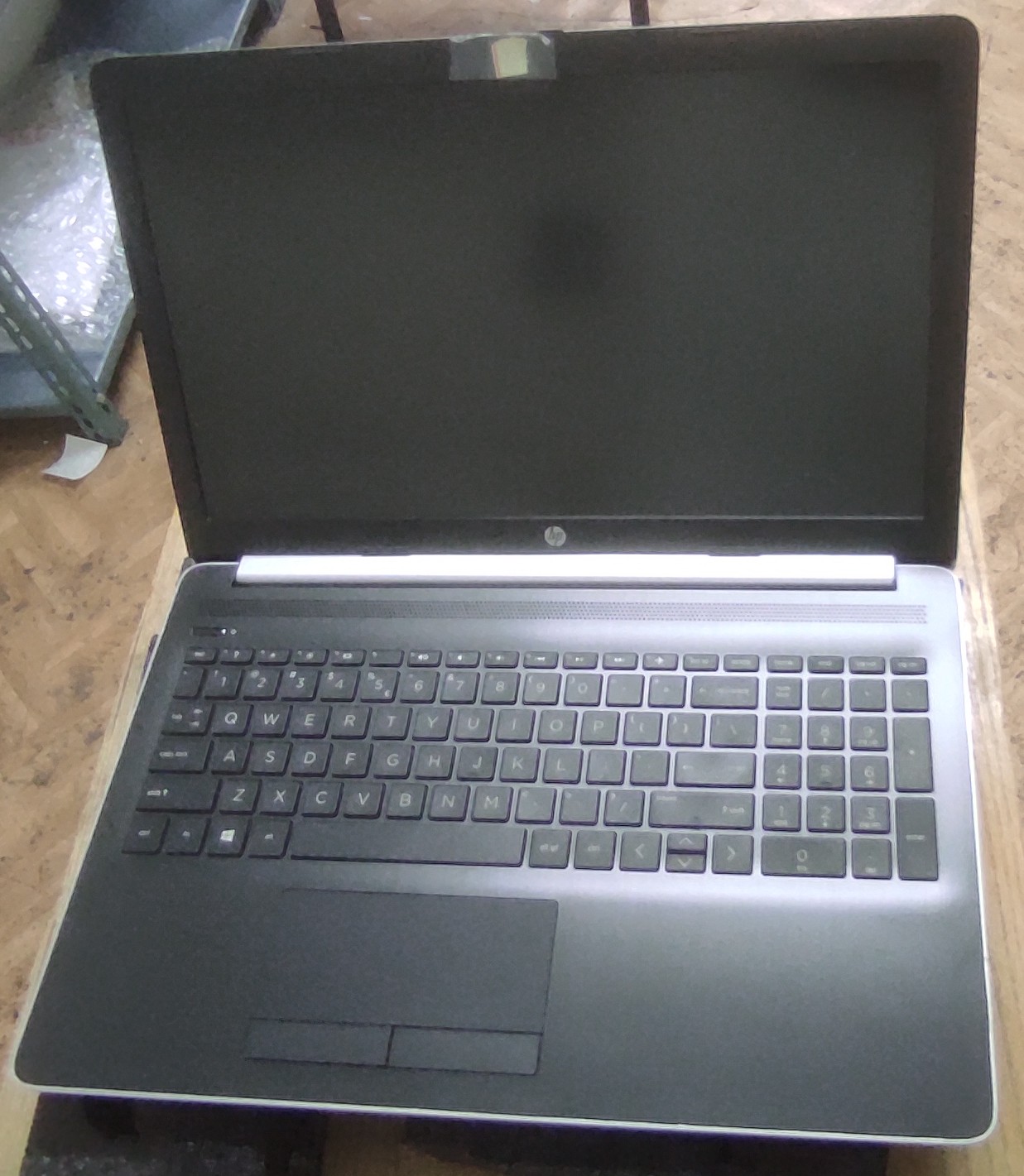 Otwarty laptop z widoczną klawiaturą w dobrym stanie.