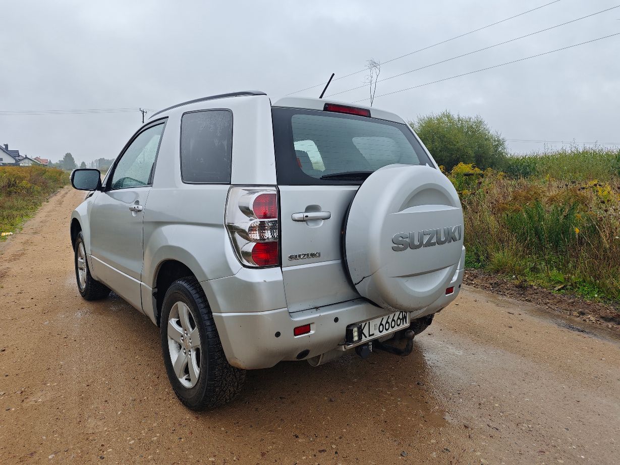 Srebrny samochód marki Suzuki Grand Vitara II w wersji trzydrzwiowej, Lewy tylni bok