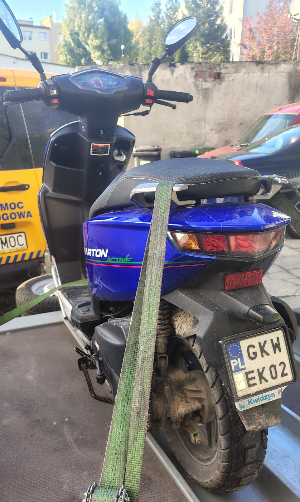 Stojący na kołach ten sam pojazd, widok z tyłu, w tym widoczna tablica rejestracyjna i czerwone lampy.