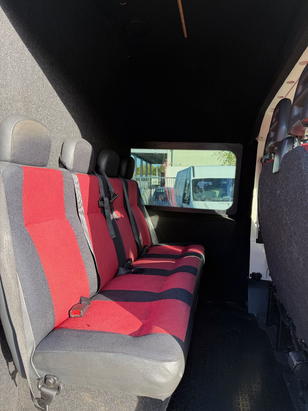 Biały Fiat Ducato, ujęcie tylnej części wnętrza kabiny pojazdu.