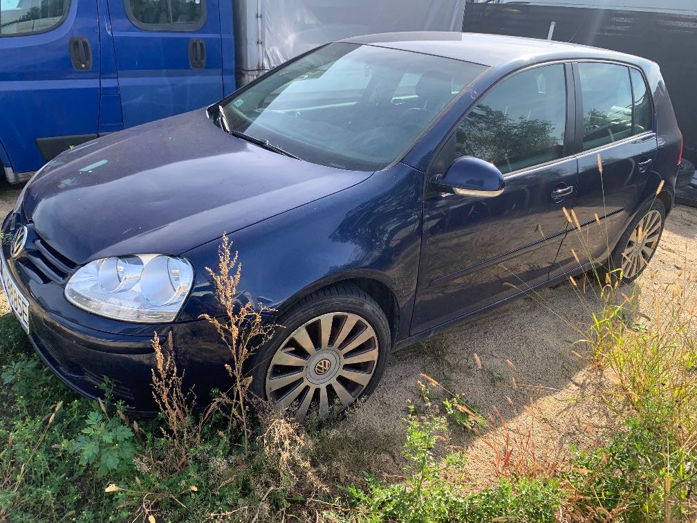 Granatowy samochód osobowy marki Volkswagen, model Golf V - widok z lewej strony