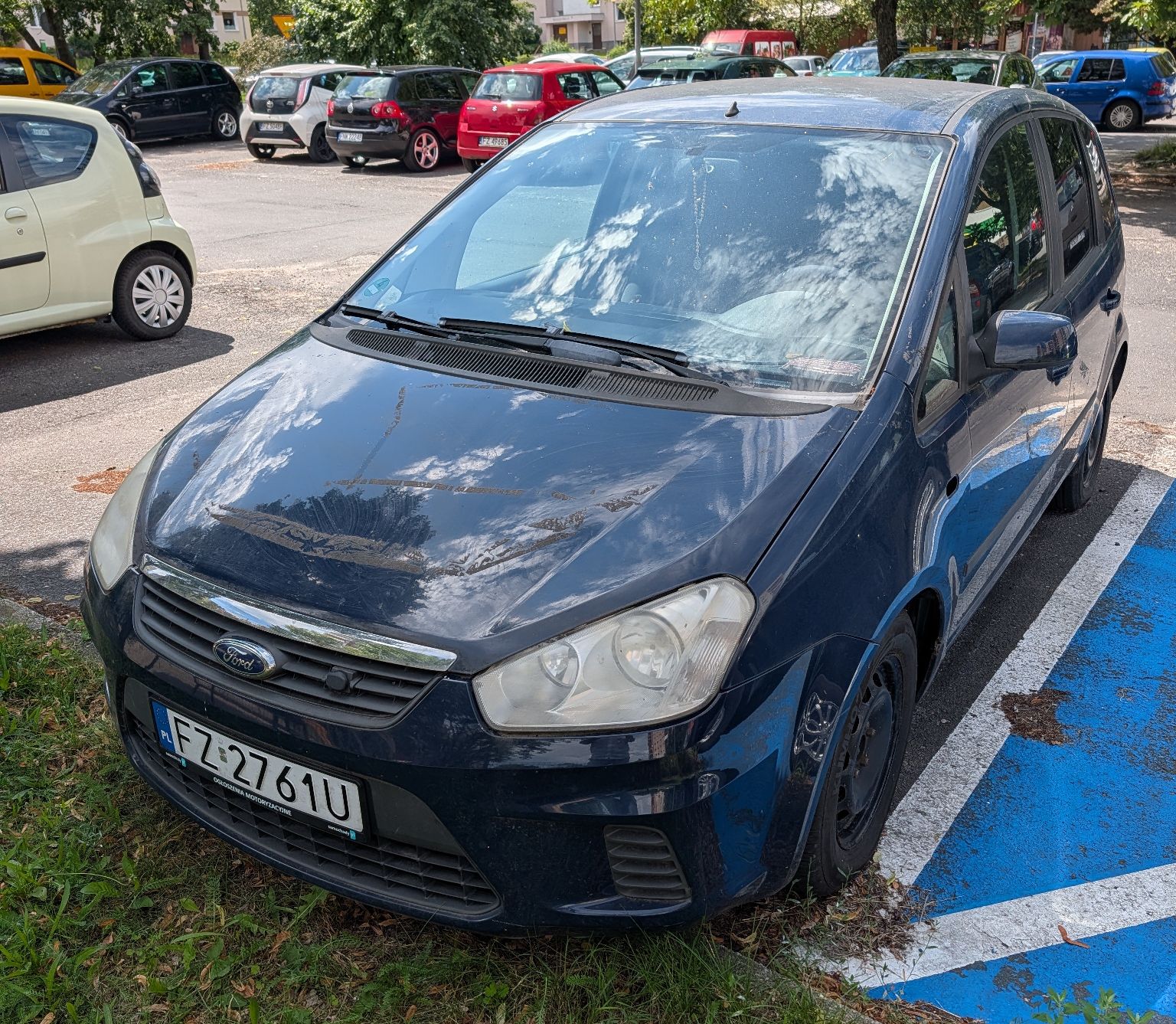 Zdjęcie przodu pojazdu. Ślady starego kleju na masce.