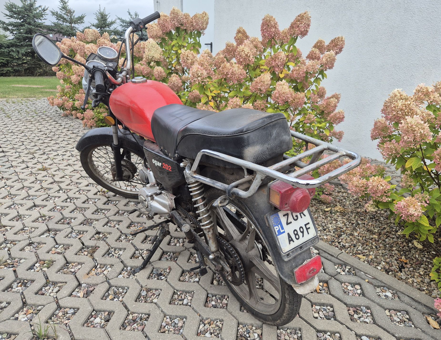 Widok motoroweru z lewej, tylnej strony. Widoczna naloty rdzy na tylnym amortyzatorze.