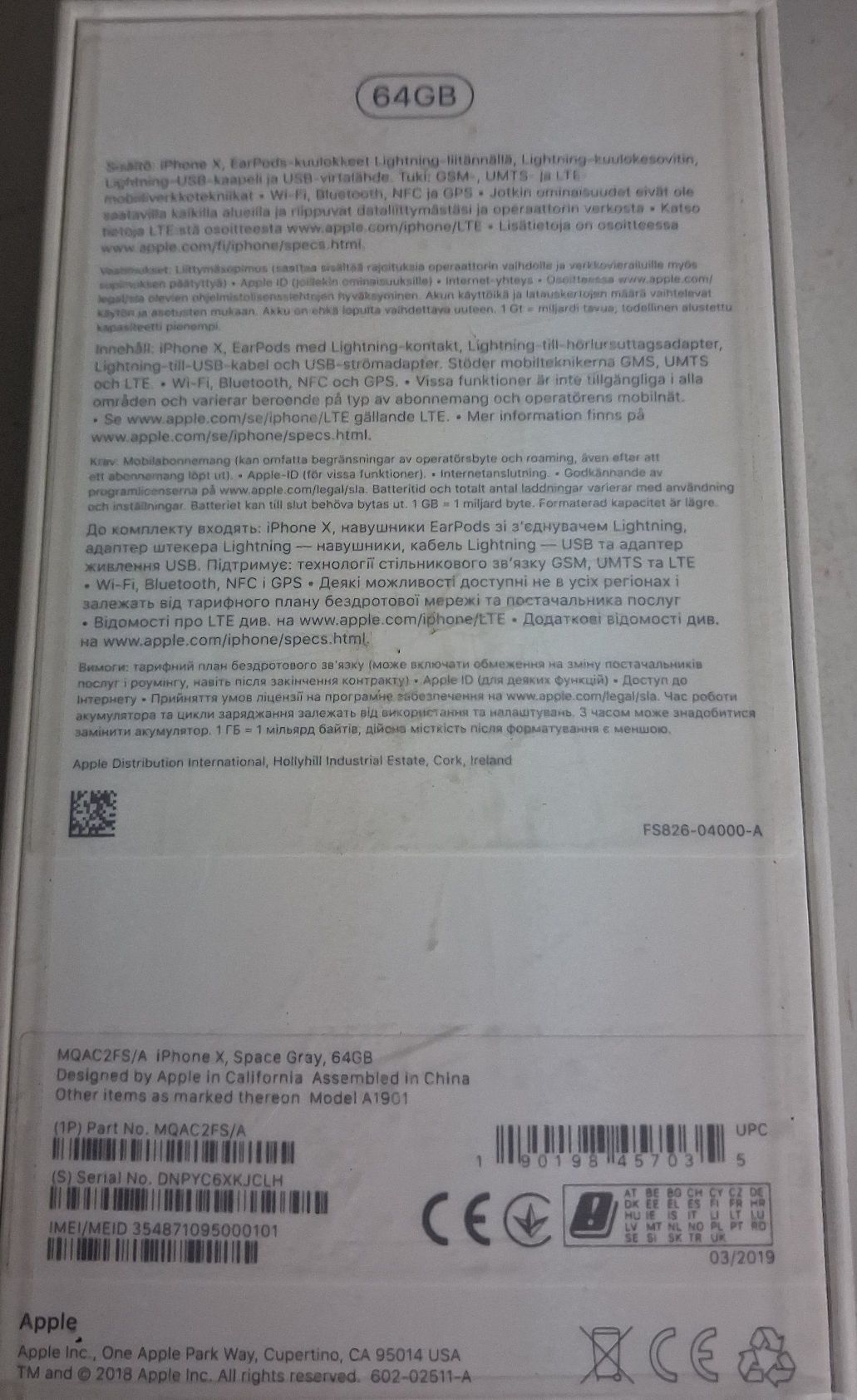 Spód opakowania smartfonu koloru białego z opisem w językach obcych i naklejką znamionową.