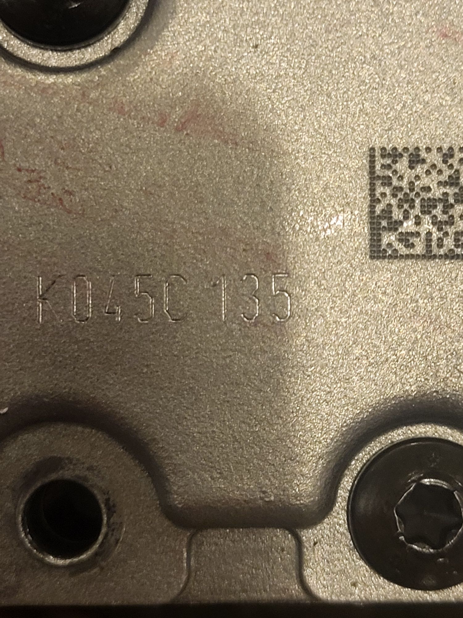 metalowa część skrzyni biegów z wybitą sekwencją znaków „K045C 135”
