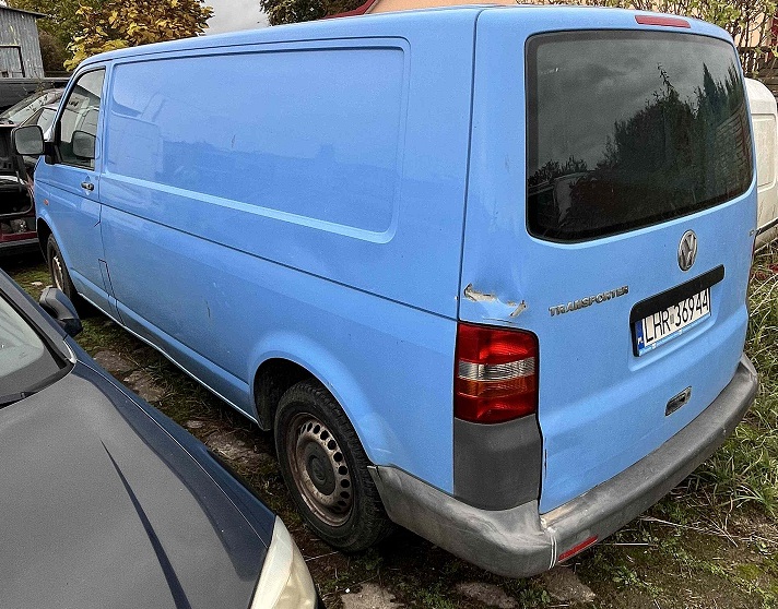 Samochód Volkswagen Transporter w kolorze niebieskim widoczny od tyłu z lewej strony.