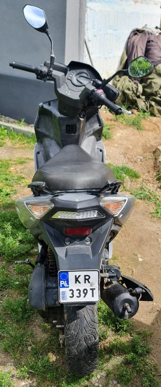 Skuter z tylnym numerem rejestracyjnym KR339T