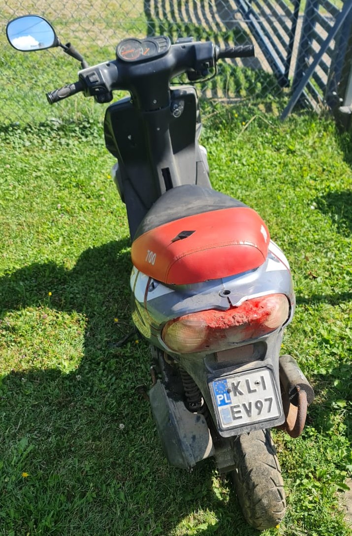 Skuter typu motorower z czerwoną kanapą i polską tablicą rejestracyjną.