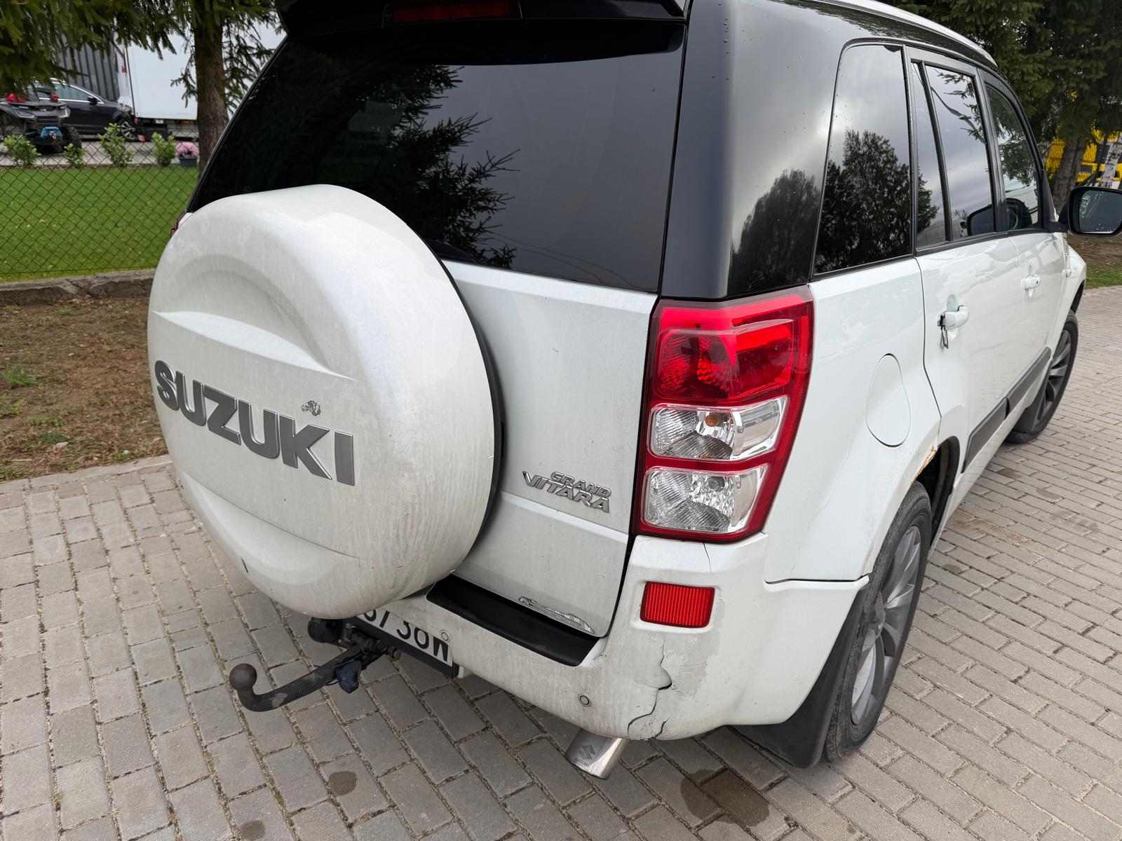 Tył pojazdu i prawa strona kolor nadwozia biały z czarnym dachem i lusterkami, uszkodzony zderzak
