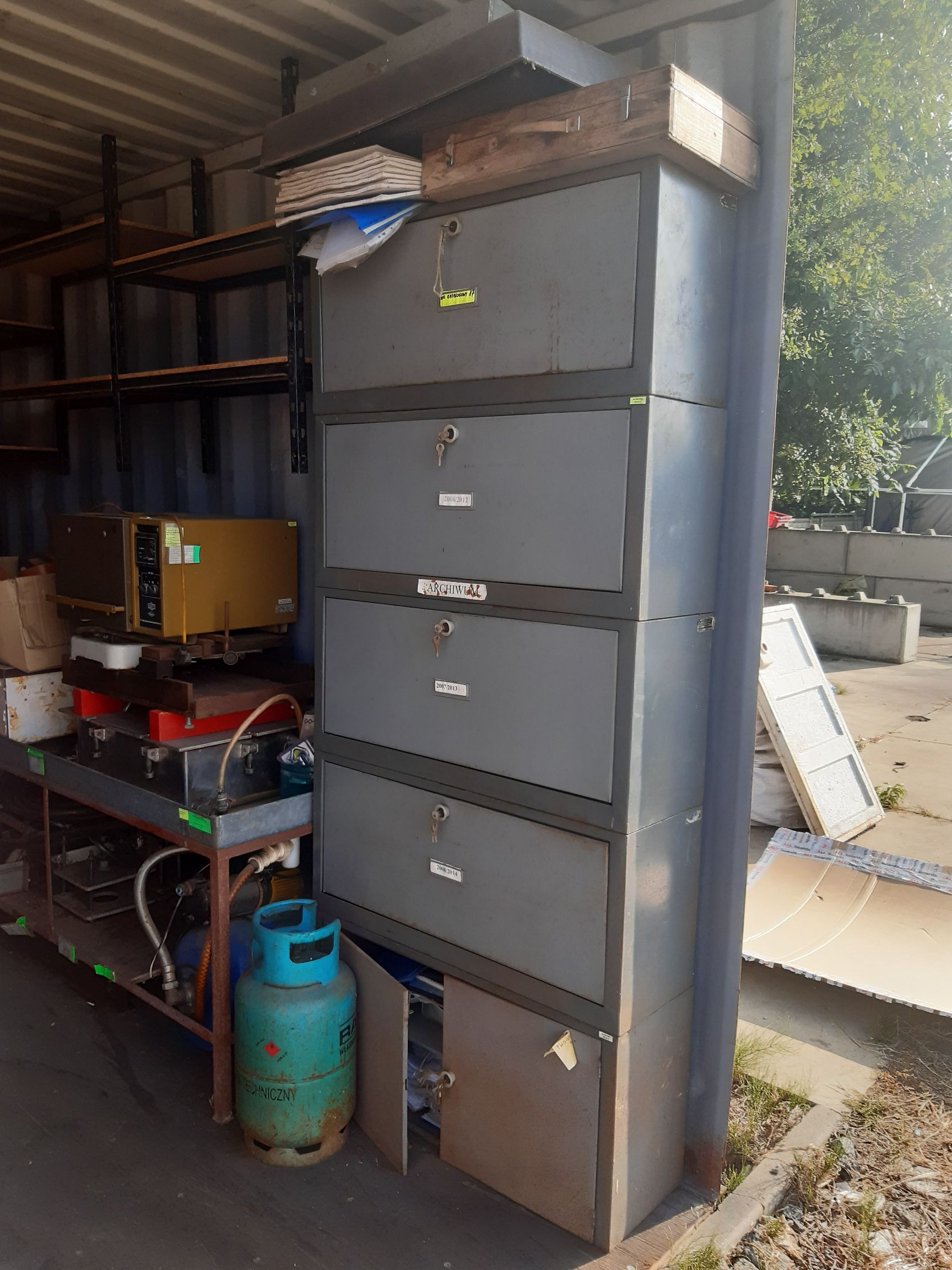 metalowa szafa kartotekowa z kilkoma dużymi szufladami i dolną szafką z drzwiczkami