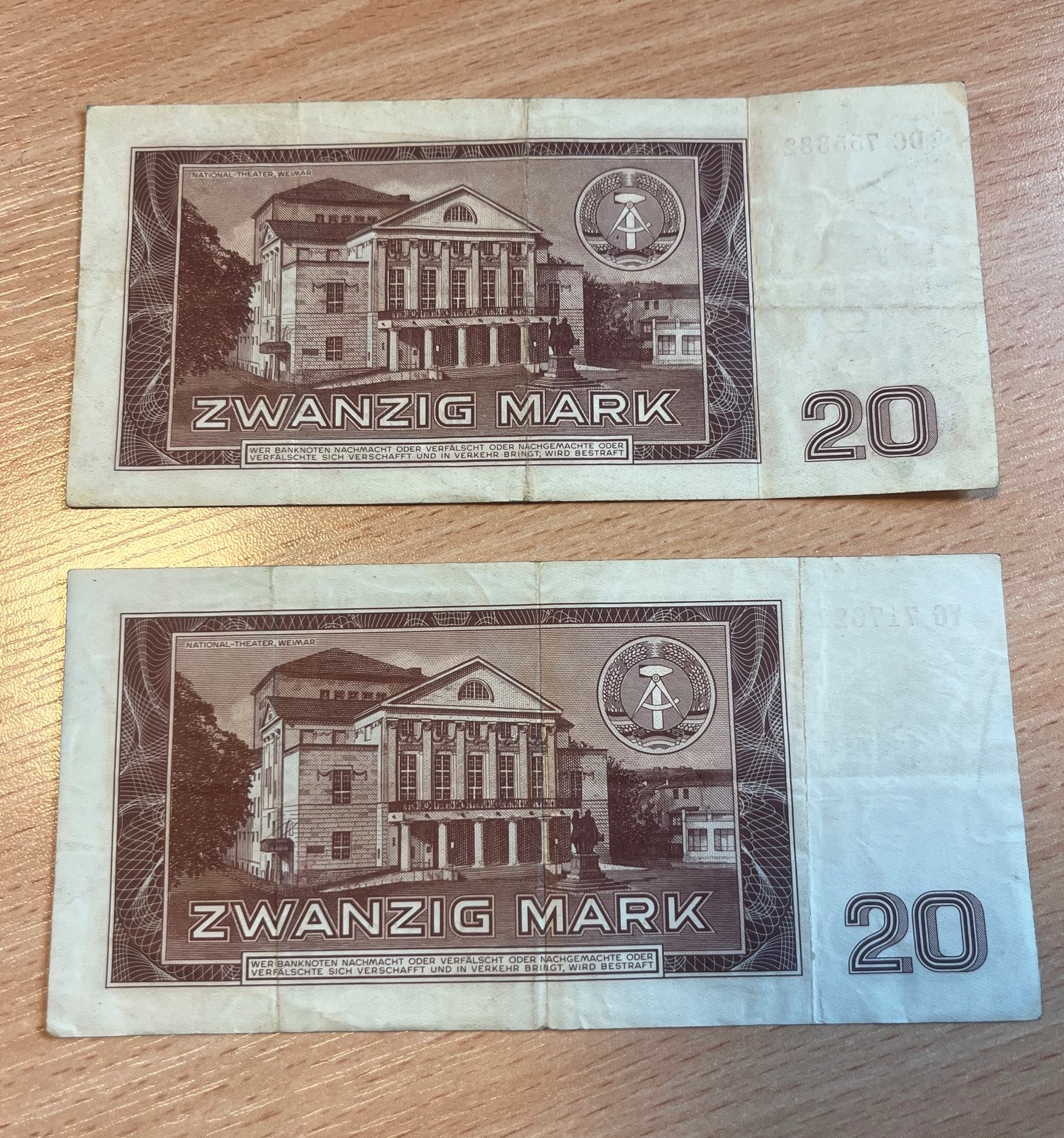 Rewersy dwóch banknotów o nominale 20 marek NRD z emisji z 1964 roku, ułożone pionowo jeden pod drugim.
