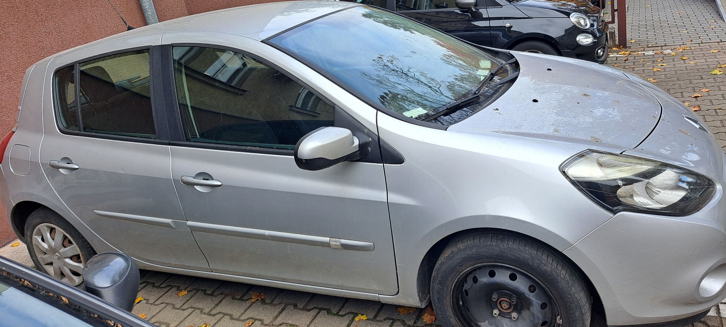 prawa strona srebrnego samochodu na karoserii widoczne niewielkie zarysowania brak kołpaka na przednim kole